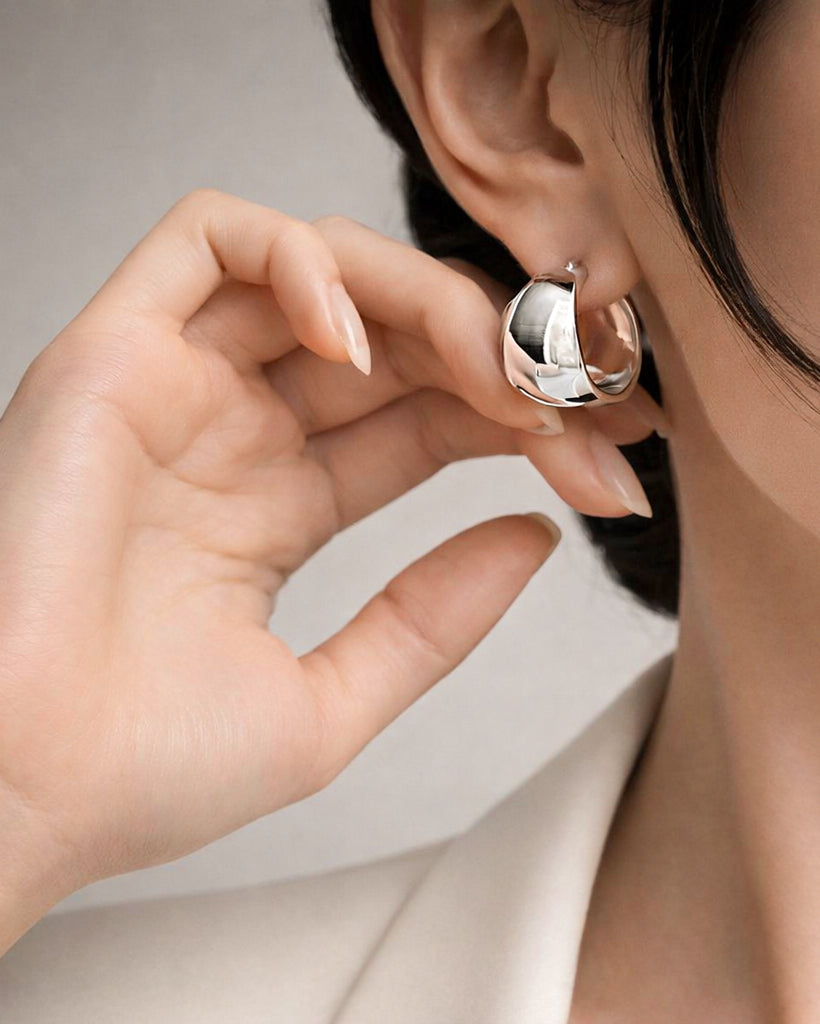 Wide chunky silver hoop earrings on model minimalist women's jewelry style look