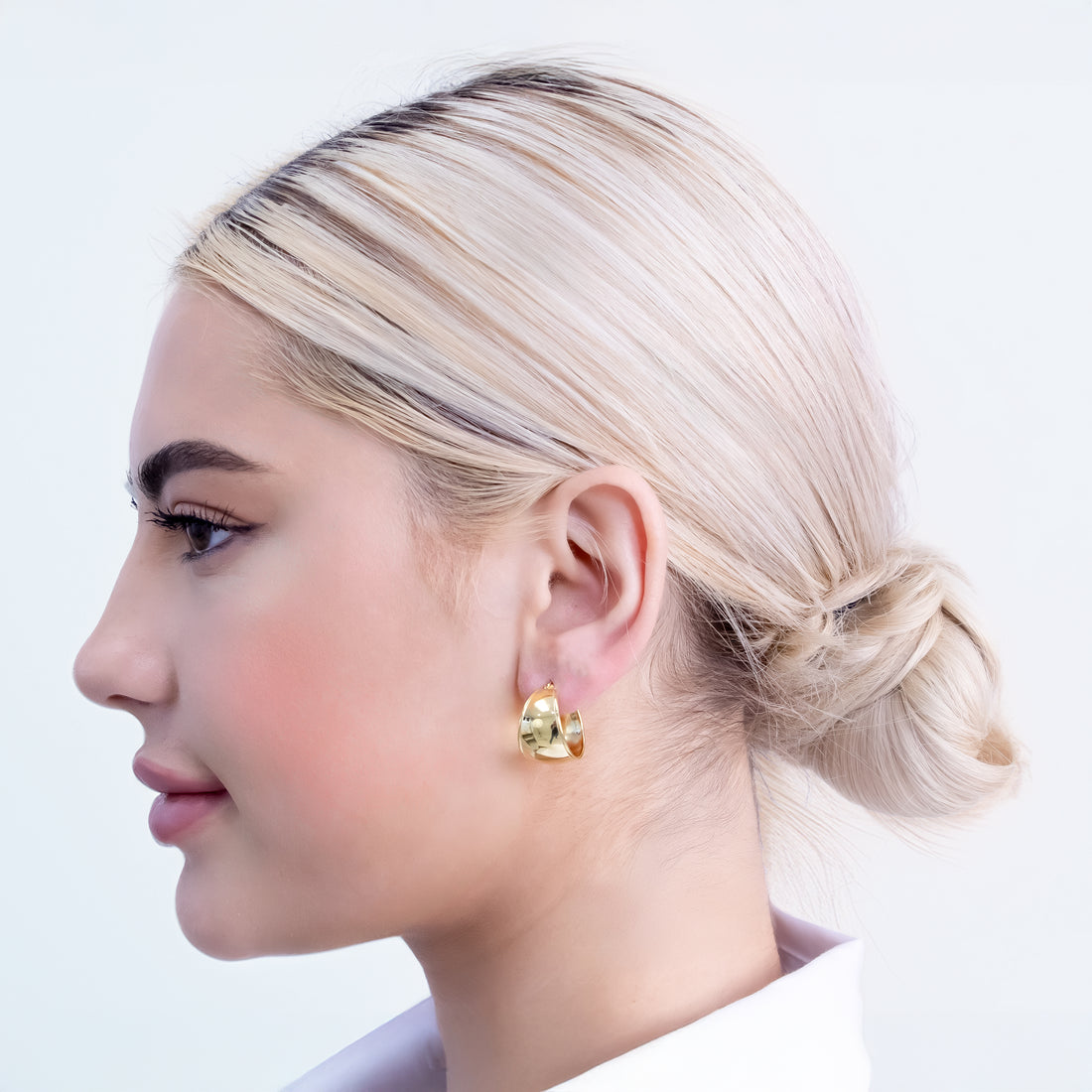 Wide gold-plated chunky hoop earrings with smooth high-polish finish and curved design