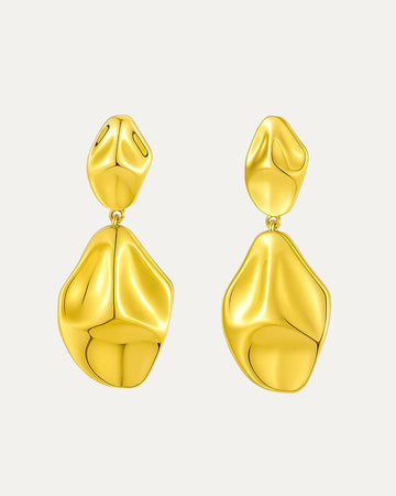 Gold earrings on a light gray background