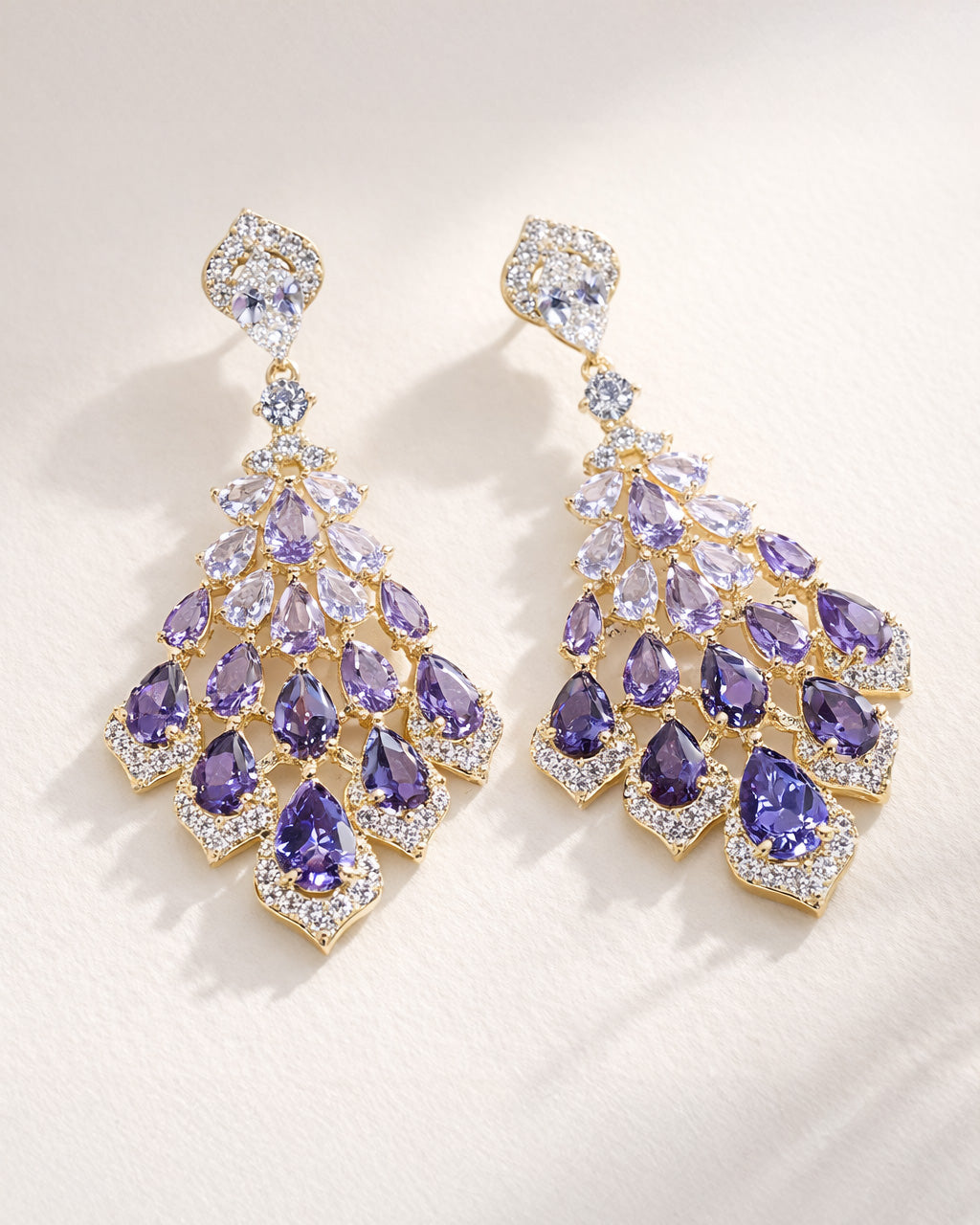 Amethyst cascade gold drop earrings with purple zirconia flat lay elegant design