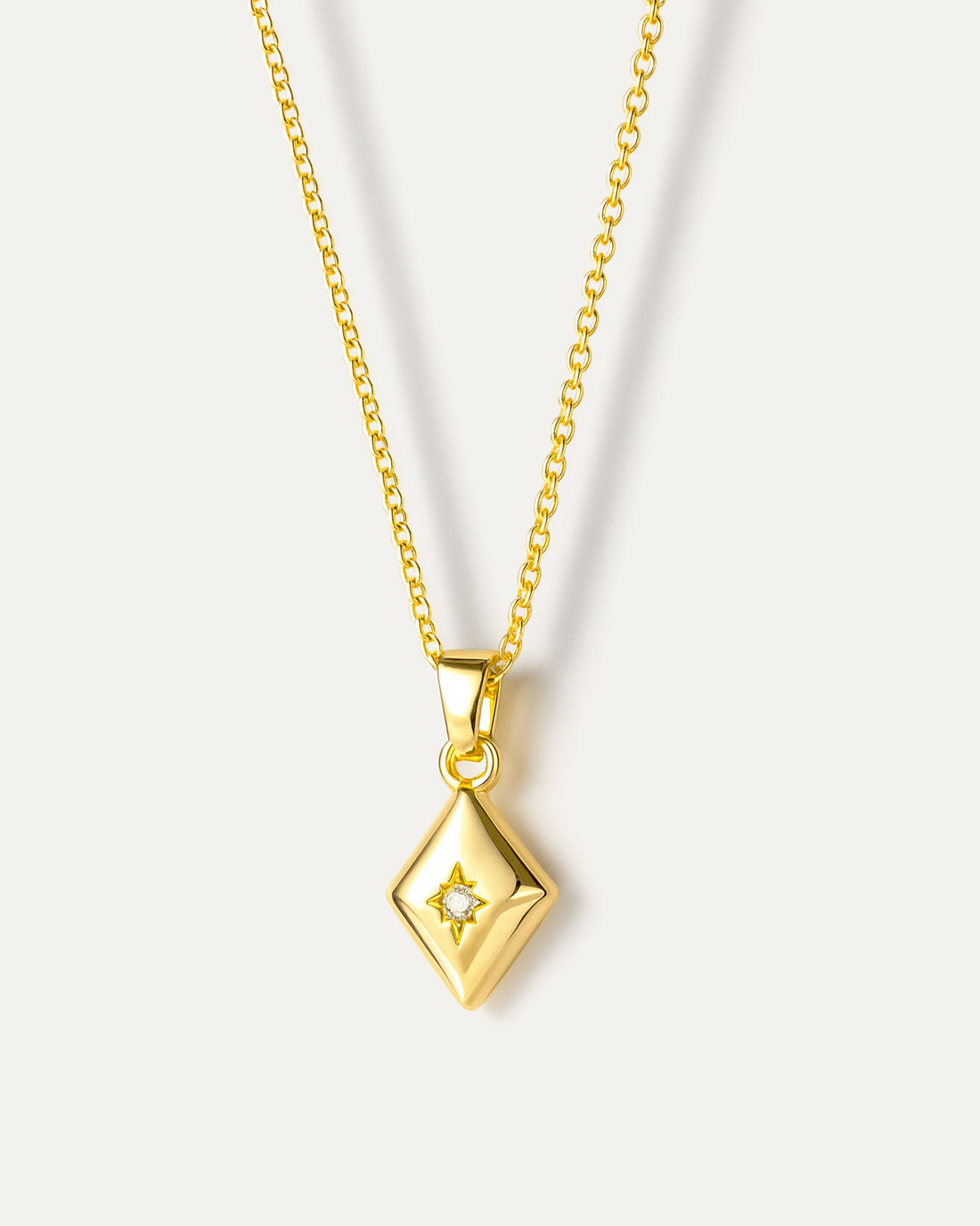 Layered necklace with natural pearl and geometric pendant, crafted from 18K gold-plated brass on neutral background