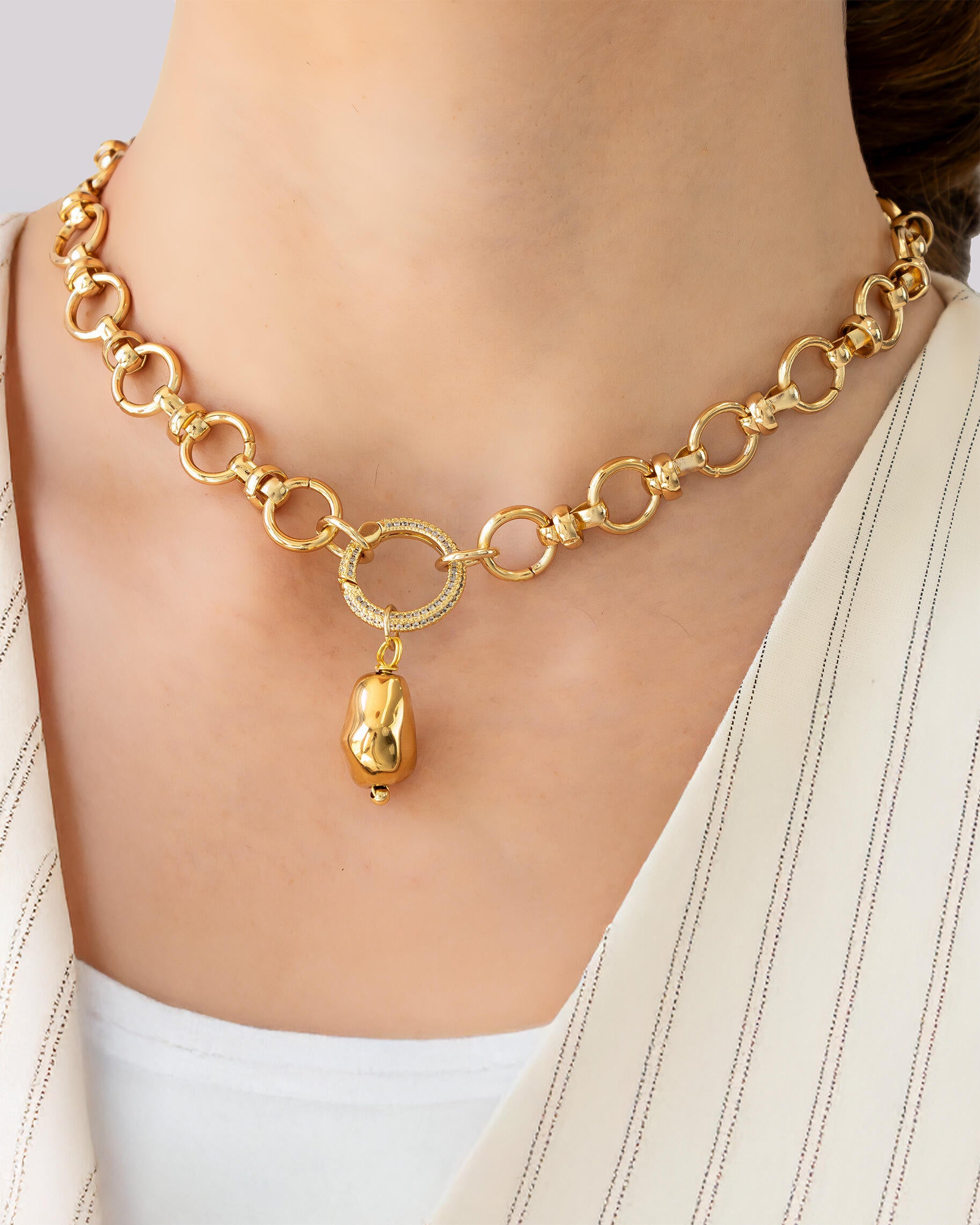 18K gold-plated brass necklace with circular link chain, pavé crystal ring, and pebble charm pendant on model