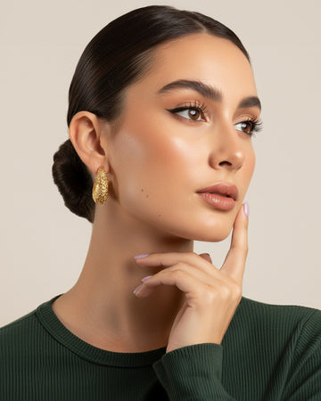 18K gold-plated baroque crescent hoop earrings worn on model with sculpted textured finish