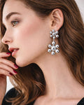 Model wearing silver cluster drop earrings with polished bead design