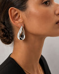 Silver teardrop statement earrings on ear modern minimalist jewelry style