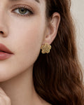 Model wearing gold-plated bubble flower stud earrings with textured design