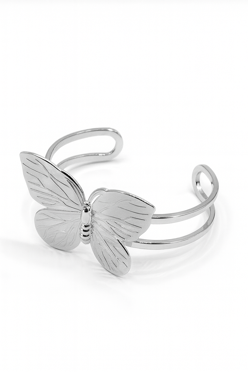Butterfly Embrace Cuff bracelet in silver-plated brass with detailed butterfly design and open cuff structure