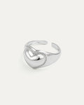 Silver heart-shaped ring on a light gray background