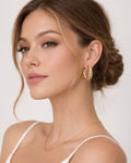 Gold rope hoop earrings worn on ear bold twisted minimalist jewelry style