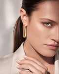 Gold rectangular hoop earrings chunky textured design worn on ear minimal