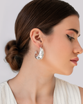 Crescent Curve Hoops in high-polish silver worn by model - sculptural crescent-shaped earrings.