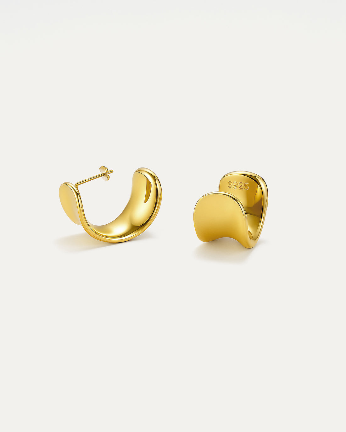 Gold hoop earrings on a light beige background