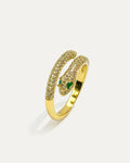 A close-up studio shot of a gold-tone ring shaped like a snake on a plain white background. The ring has a wrap-around design