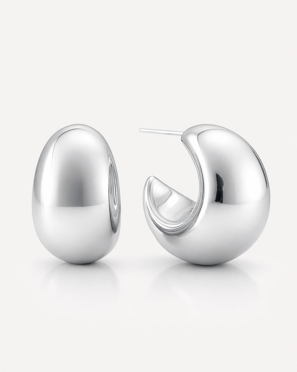 Silver-plated curve dome hoop earrings with a smooth high-polish finish and bold rounded sculptural design by Jadejuri