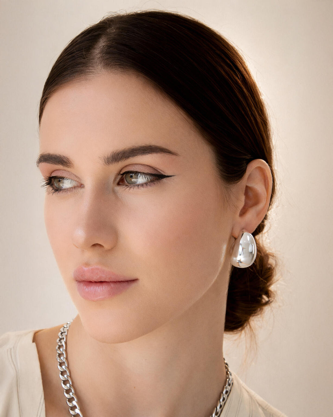 Silver-plated curve dome hoop earrings with a smooth high-polish finish and bold rounded sculptural design by Jadejuri