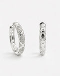 Silver pavé hoop earrings with diamond-like detailing and polished silver finish, side view