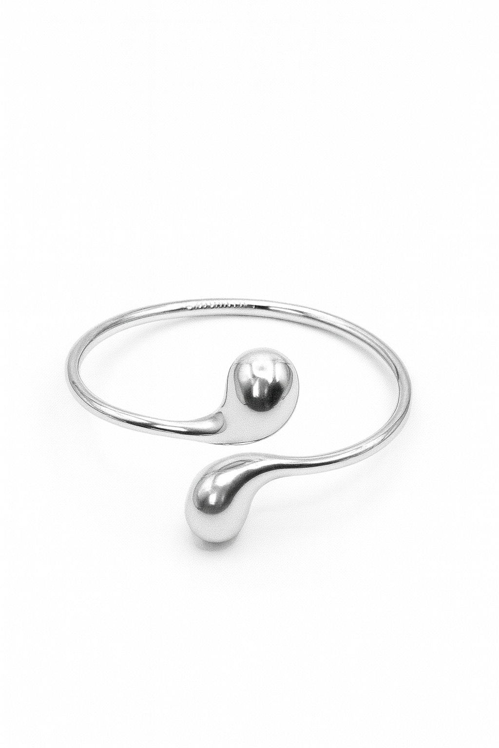 Eclipse Drop Cuff in silver-plated brass with double droplet ends and a polished sculptural finish