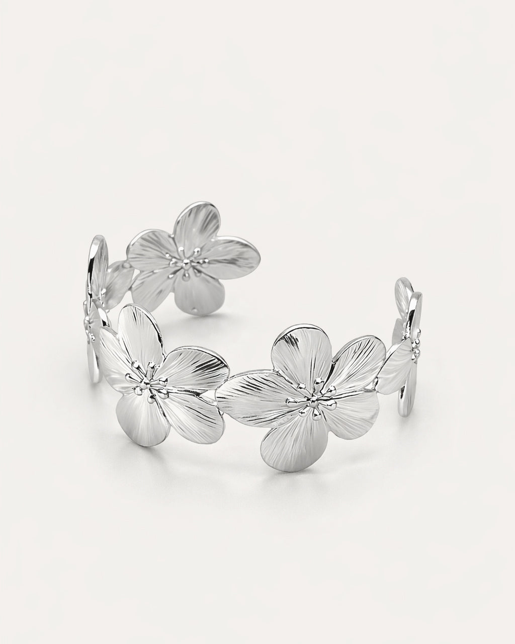 Flora Bloom Cuff in silver-plated brass featuring detailed flower motifs in an open cuff design