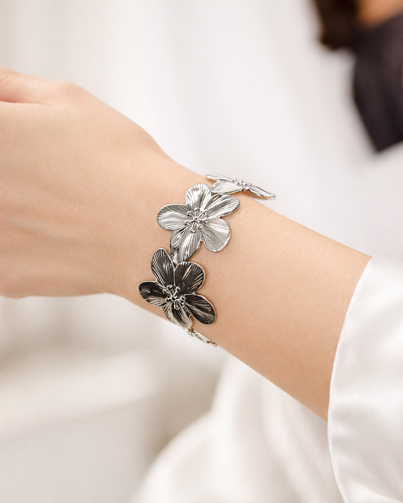 Silver-plated floral cuff bracelet on wrist, flower statement bangle for women