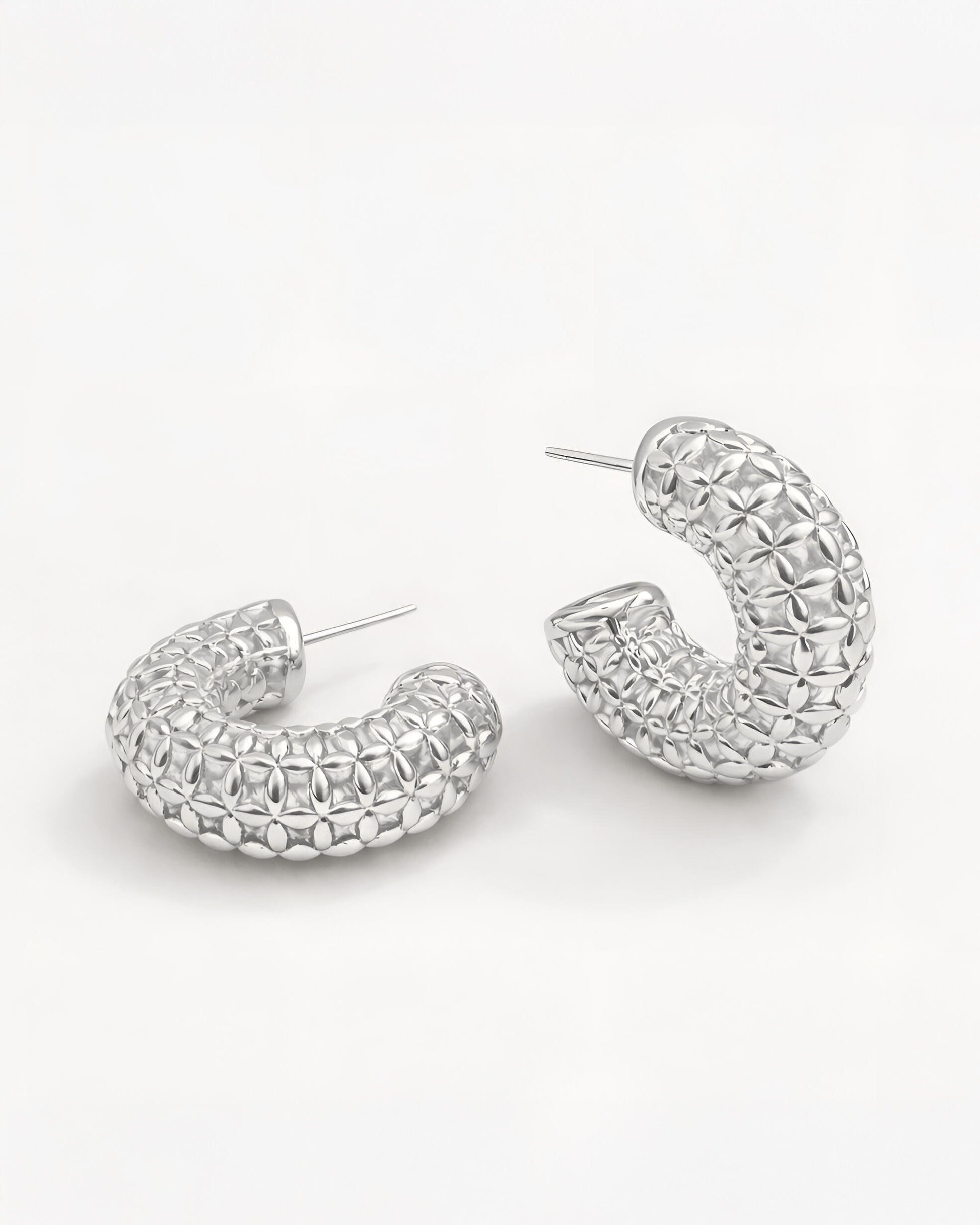 Side close-up view of silver-plated floral lattice hoop earrings featuring a sculpted petal-inspired texture and bold curved 
