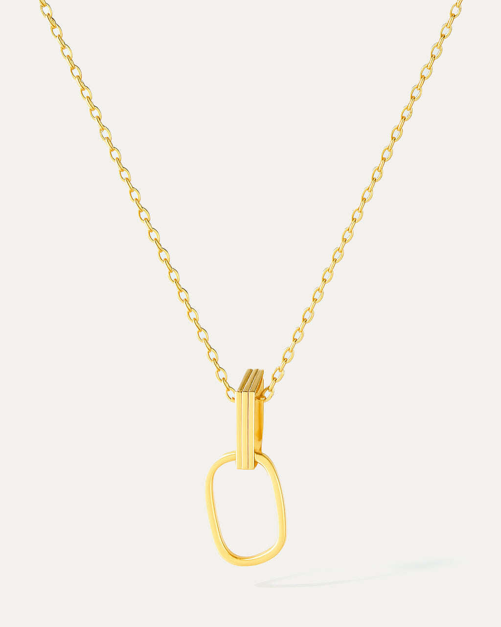 Gold necklace with a unique pendant on a light gray background