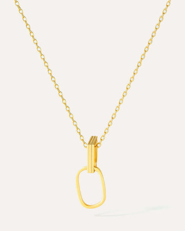 Gold necklace with a unique pendant on a light gray background