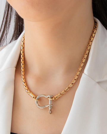 Model wearing gold chain necklace with shackle clasp detail and polished 18K gold-plated finish