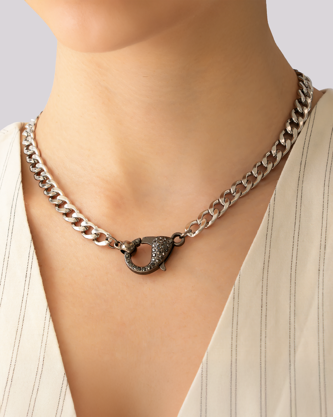 Model wearing gunmetal choker necklace with panther claw pavé clasp and polished curb chain.