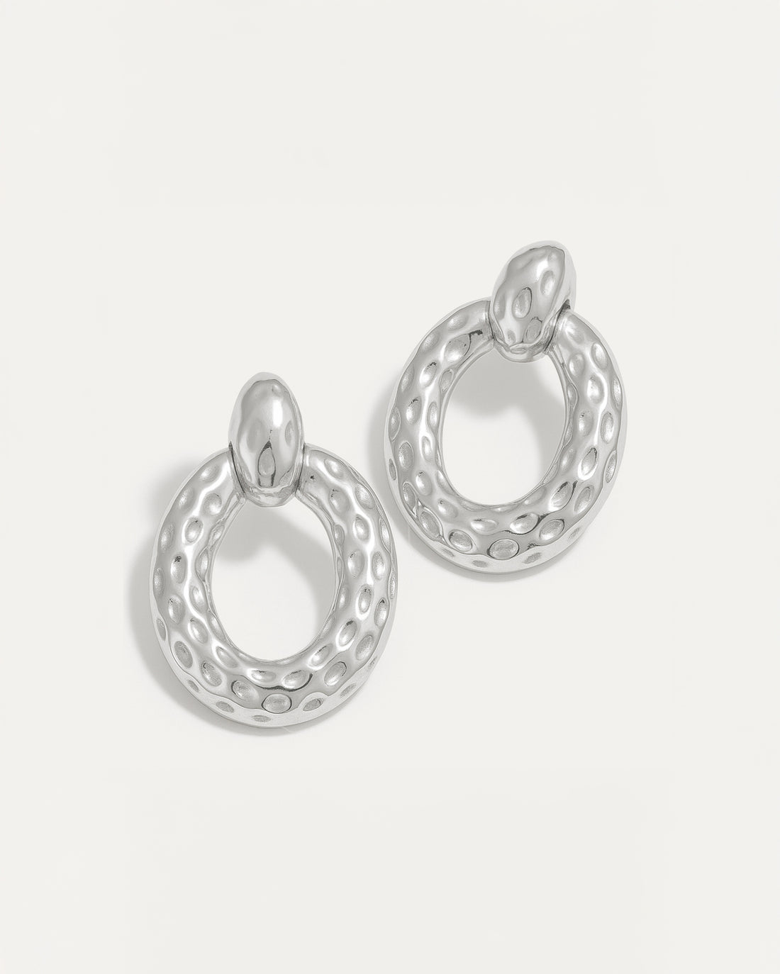 Silver hammered oval stud earrings with textured surface and high-polish finish – lightweight and sculptural.