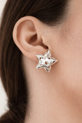 Model wearing silver-plated hollow star stud earrings with polished finish and modern geometric design