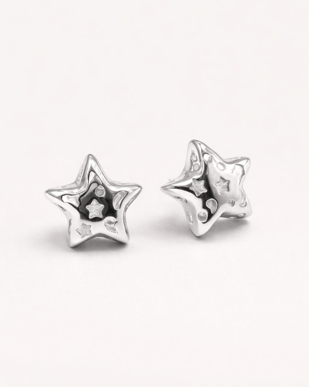 silver-plated hollow star stud earrings with cutout star details, top view minimalist jewelry design
