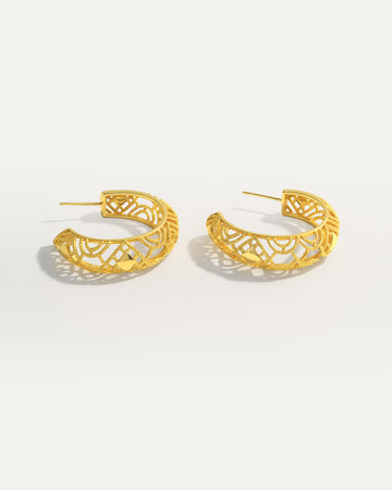 18K gold-plated openwork hoop earrings with geometric filigree design on studio background