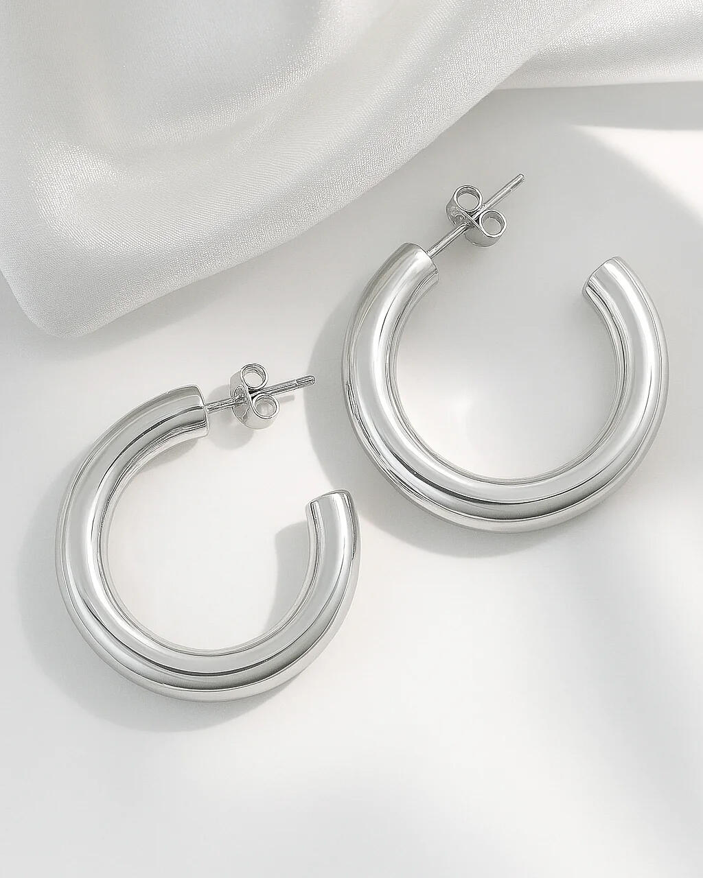 silver-plated bold hoop earrings with chunky modern design on white background