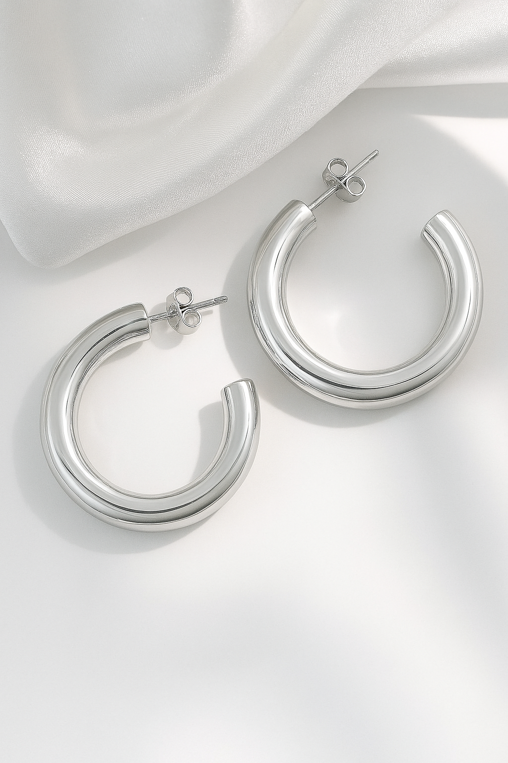 silver-plated bold hoop earrings with chunky modern design on white background