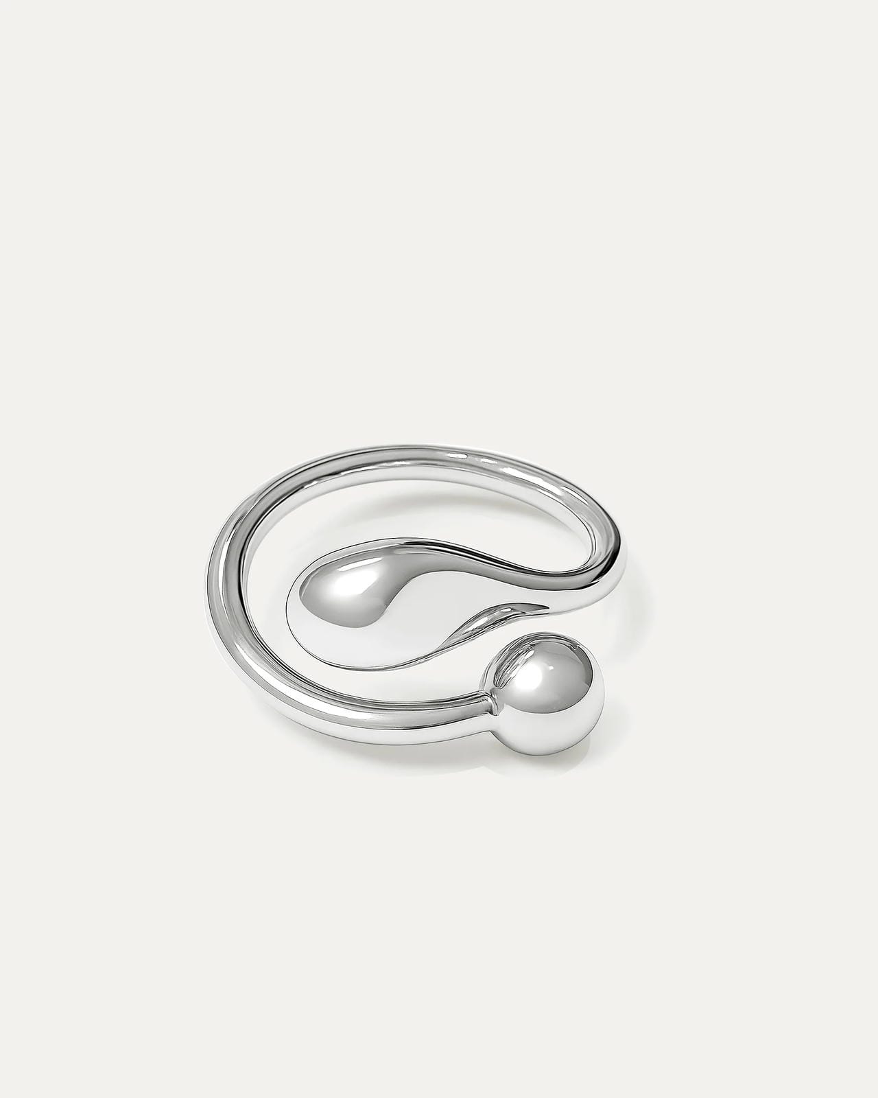 A sleek, polished silver open-cuff ring featuring a fluid, minimalist design. The ring wraps around, terminating in two contr