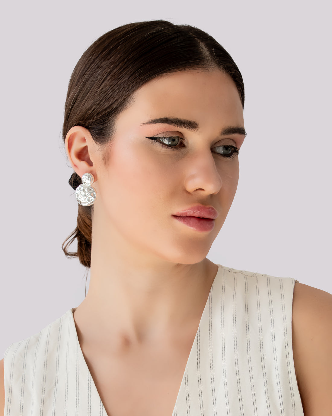 Sterling silver dome-shaped Lunar Impression studs with textured crater surface, minimal moon-inspired earrings