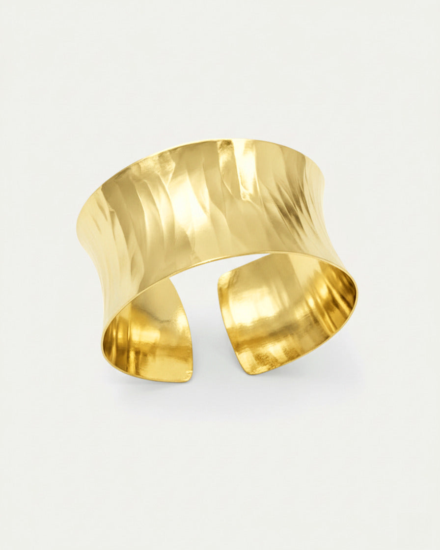 Gold hammered cuff bracelet with wide curved design and polished 18K gold-plated finish