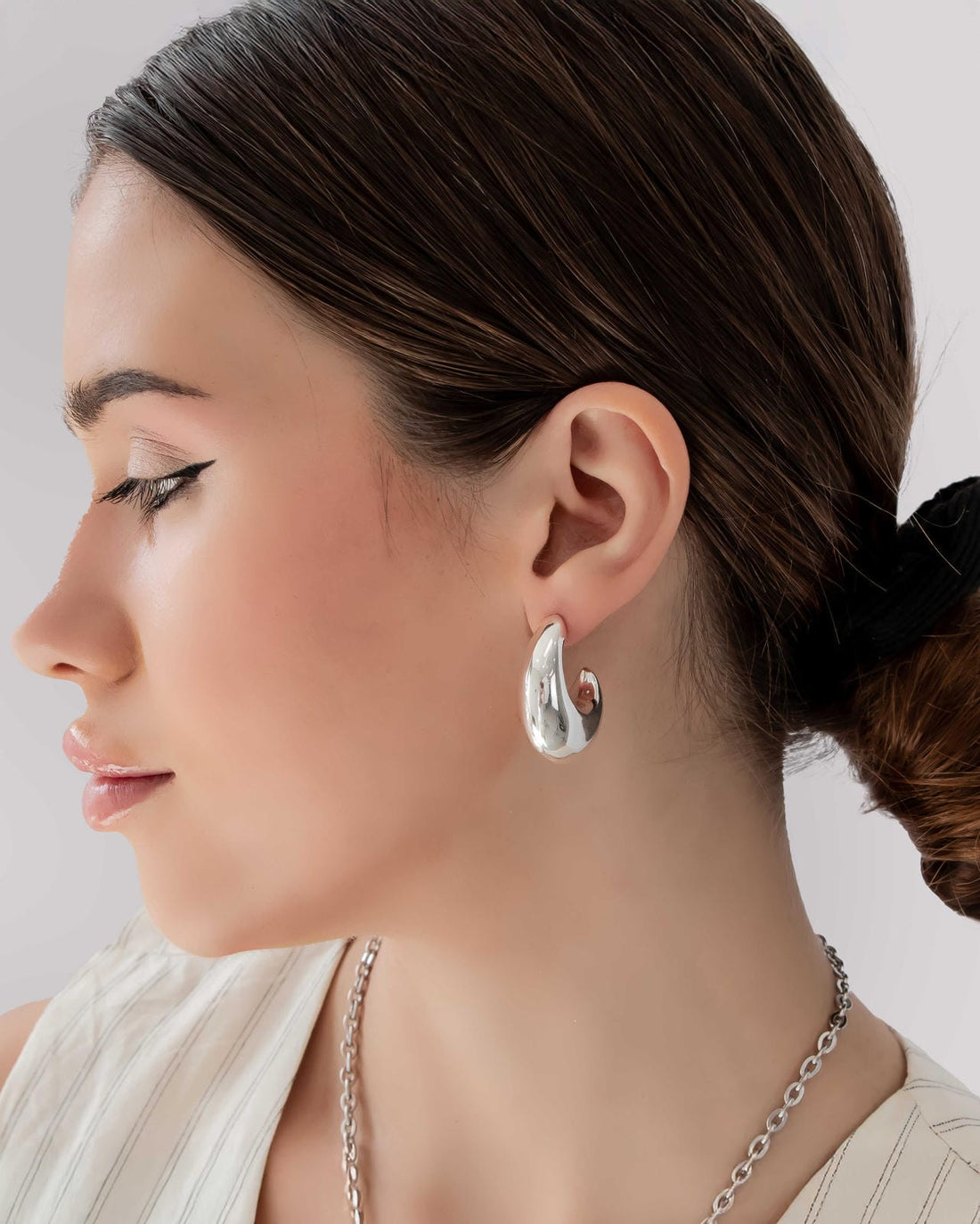 Pair of silver hoop earrings on a light gray background