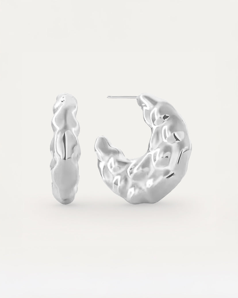 Molten silver hoop earrings with crinkled surface design, chunky artistic style.