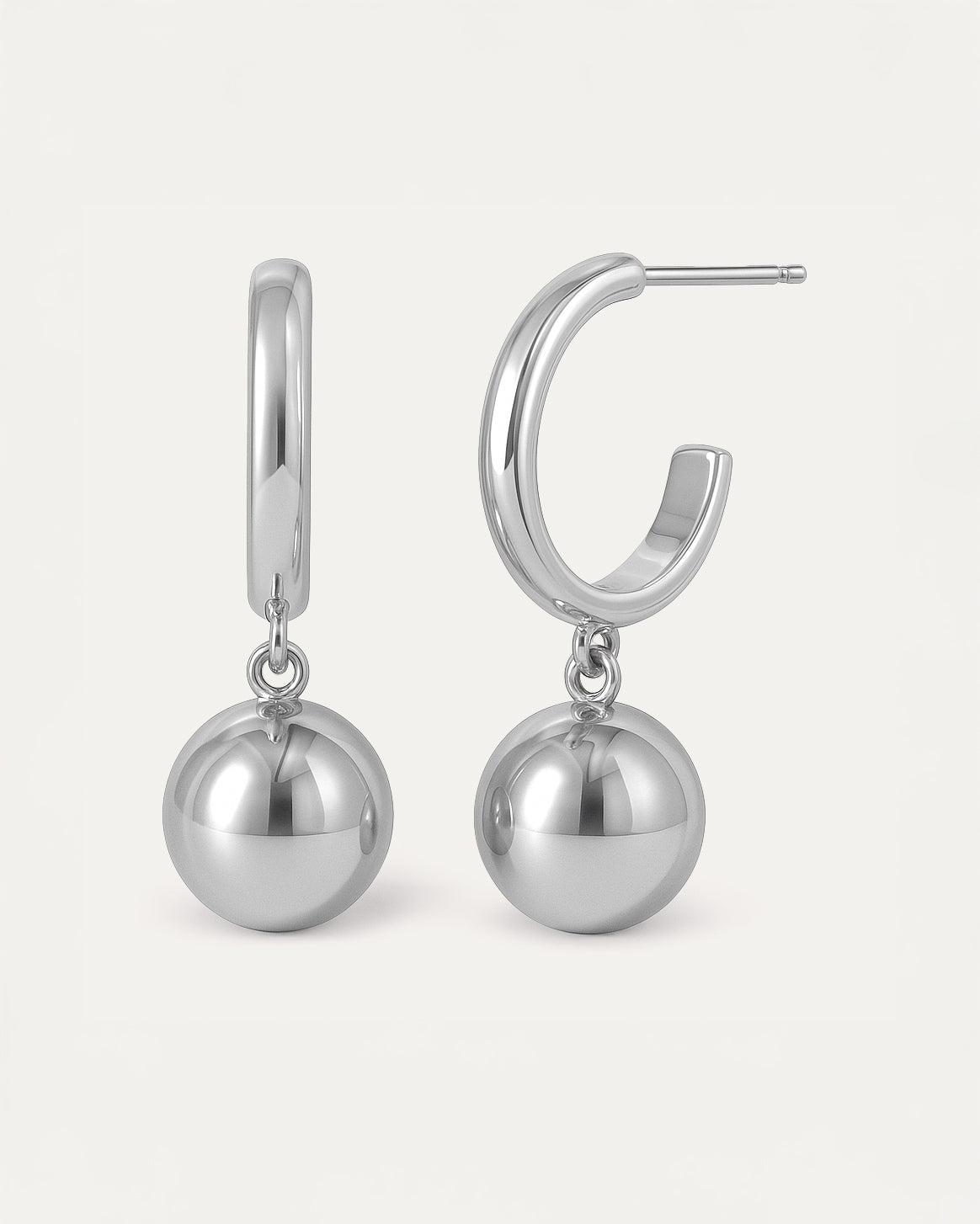 Silver hoop earrings with dangling polished sphere charm in minimalist drop design.