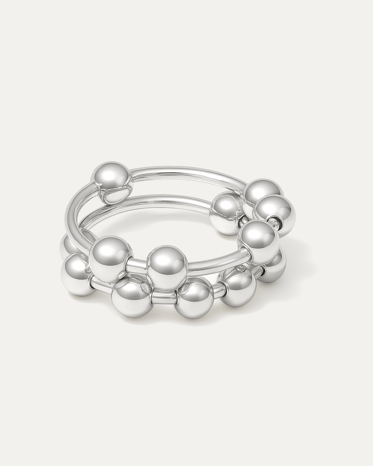 silver-plated sculptural ring with double bands and polished ball accents on white background