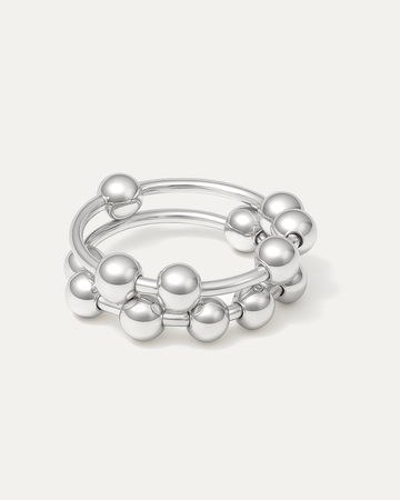 silver-plated sculptural ring with double bands and polished ball accents on white background
