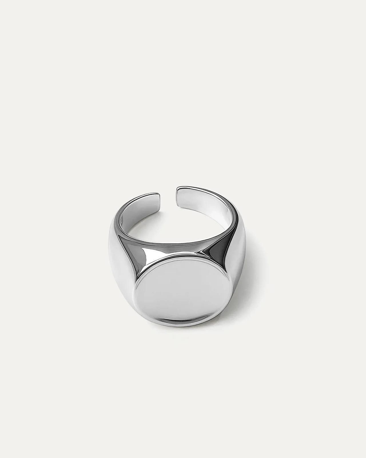 A chunky, adjustable silver signet ring with a minimalist, polished finish. The design features a smooth, oval-shaped top pla