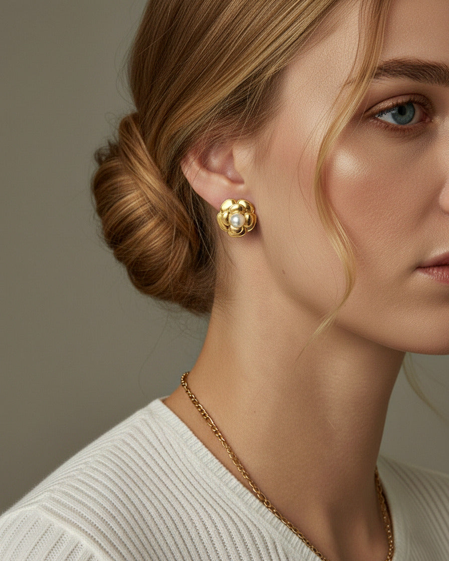 Model wearing gold pearl flower stud earrings with polished 18K gold-plated finish and elegant design