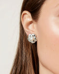 Model wearing silver pearl flower stud earrings with polished silver-plated finish and classic design