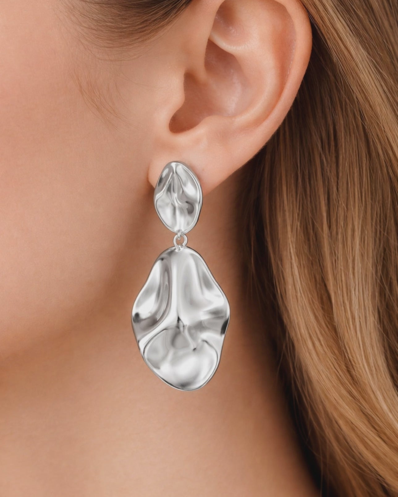 Model wearing abstract silver dangle earrings with sculptural organic design