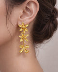 Gold flower drop earrings on ear elegant statement floral jewelry design