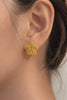 Close-up gold-plated bubble flower stud earrings with textured design