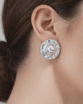 Silver-plated dome stud earrings with sculptural texture, worn on ear