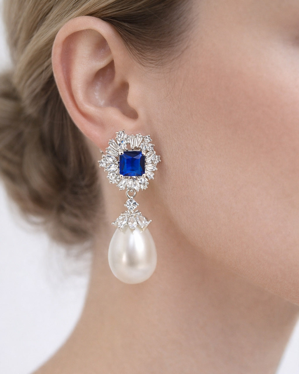 Royal azure halo pearl drop earrings worn on ear with cubic zirconia silver plated